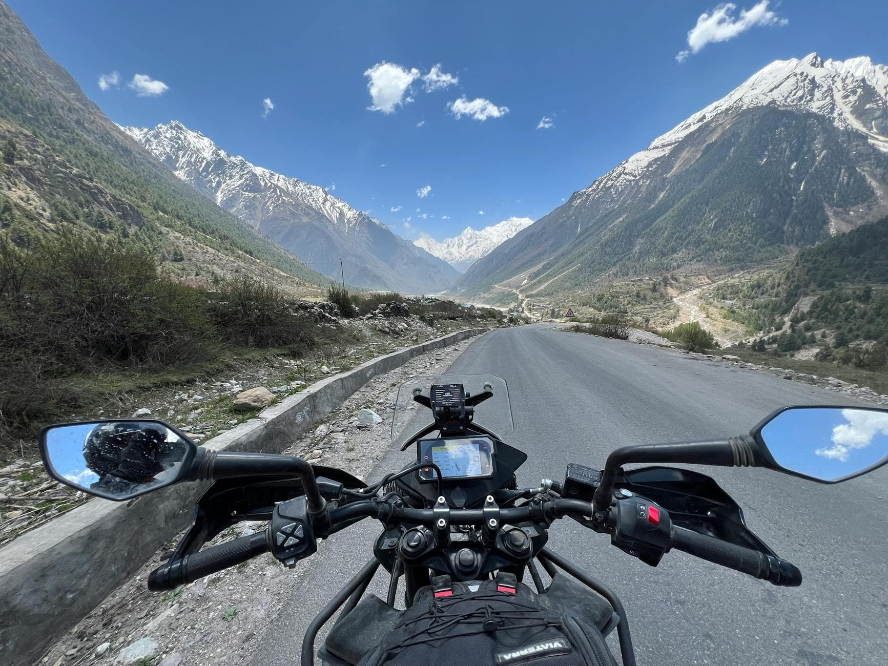 Explore scenic mountain roads on a motorcycle journey under blue skies.