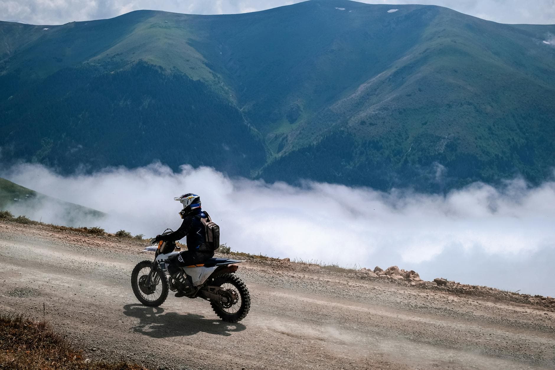 A lone motorcyclist rides on a mountain road above the clouds in Trabzon, Türkiye.